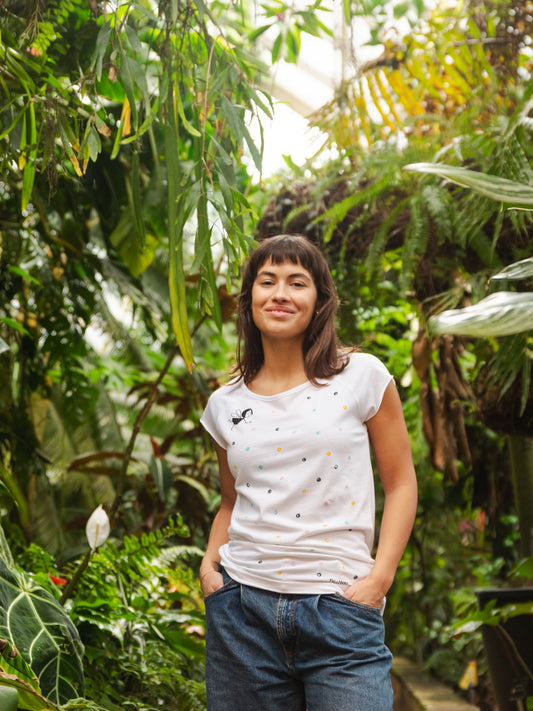 FellHerz Damen T-shirt Konfettimädchen weiß mit Raglan-Ärmeln bio fair und vegan hergestellt. Weißes T-Shirt mit bunten Konfetti-Tupfen und einem kleinen geflügelten Mädchen auf der Vorderseite.